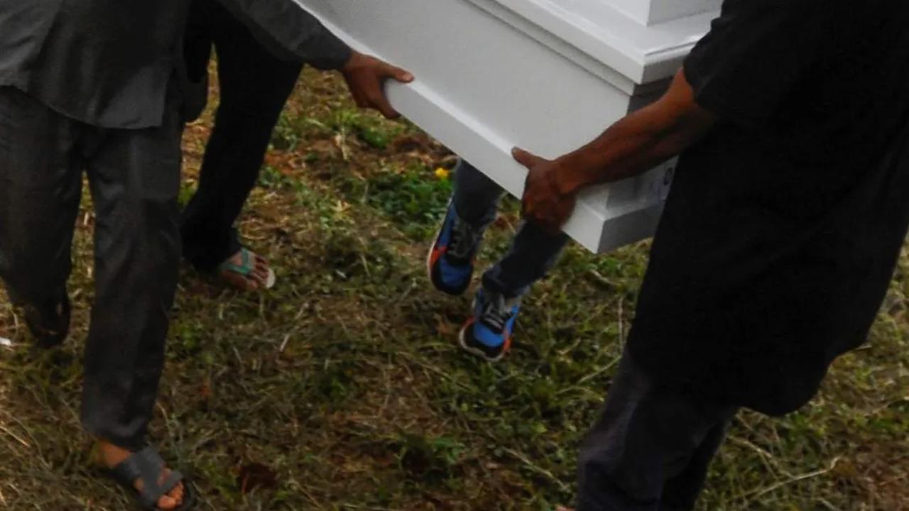 Sesampai di pemakaman, peti jenazah keempat anak itu satu per satu dikeluarkan dari dalam mobil ambulan.
