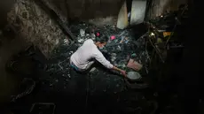 Warga mengais sisa barang yang masih bisa diselamatkan dari puing rumah yang terbakar di Jalan Kramat Pulo Dalam, Senen, Jakarta Pusat, Jumat (9/10/2026). (KLY/Budy Santoso)