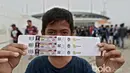 Seorang suporter cilik menunjukan tiket yang dibelinya pada loket pembelian tiket di Stadion Pakansari, Bogor, Sabtu (11/3/2017). (Bola.com/Nicklas Hanoatubun)