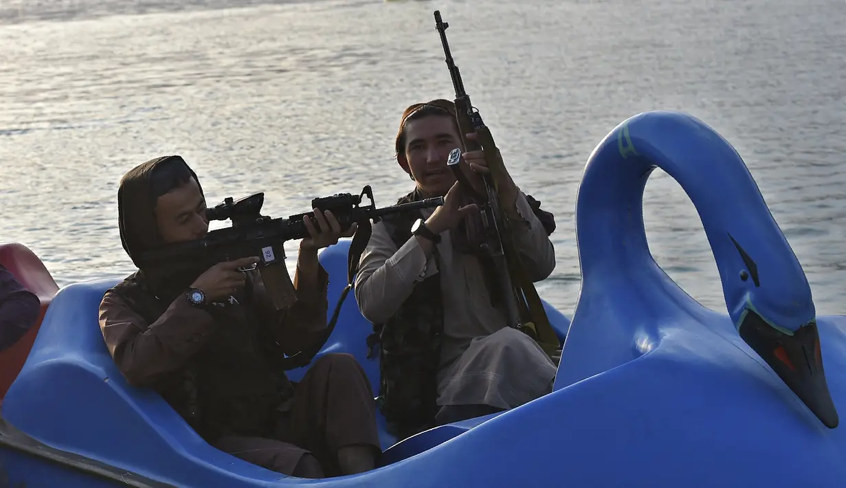 Sejumlah pasukan Taliban saat menaiki perahu kayuh di Danau Qargha di sebuah pekan raya di Kabul barat (28/9/2021). Mereka mengaku datang ke danau ini untuk bersenang-senang. (AFP/Wakil Kohsar)
