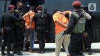 Anggota Densus 88 Antiteror menggiring terduga teroris masuk ke dalam mobil saat tiba di Bandara Soekarno-Hatta, Tangerang, Banten, Kamis (18/3/2021). Polri memindahkan 22 terduga teroris jaringan kelompok Jamaah Islamiyah (JI) dari Jawa Timur ke Jakarta. (merdeka.com/Imam Buhori)