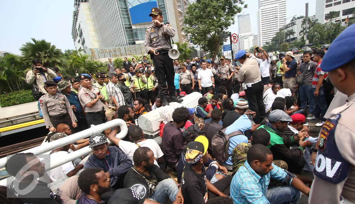 Mahasiswa yang tergabung dalam Aliansi Mahasiswa Papua (AMP) terkapar saat bentrok dengan petugas kepolisian saat aksi perayaan ekspresi identitas Papua di kawasan Bunderan Hotel Indonesia, Jakarta Pusat, Selasa (1/12). (Liputan6.com/Immanuel Antonius)