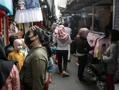 Warga berbelanja pakaian yang dijual pedagang kaki lima di Jalan Jati Baru II, Tanah Abang, Jakarta, Senin (18/5/2020). Meski kawasan niaga Pasar Tanah Abang telah tutup selama masa PSBB, namun sebagian oknum pedagang tetap menggelar lapaknya di sejumlah titik. (Liputan6.com/Faizal Fanani)
