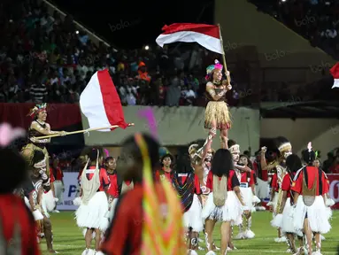 Penari mengibarkan bendera Merah-Putih saat acara pembukaan Torabika Soccer Championship 2016 di Stadion Mandala, Jayapura, Papua, Jumat (29/4/2016). (Bola.com/Nicklas Hanoatubun)