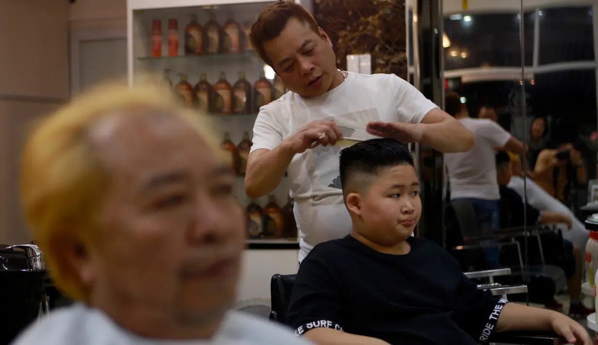 <p>Le Phuc Hai, 66 tahun (kiri) dan To Gia Huy , 9 tahun, setelah rambut mereka dipangkas dengan gaya pemimpin Korea Utara Kim Jong-un dan Presiden Amerika Serikat, Donald Trump di sebuah salon di Hanoi, Vietnam, 19 Februari 2019. (AP/Hau Dinh)</p>