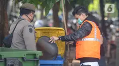 Seorang pelanggar dihukum membersihkan sampah saat Operasi Yustisi Protokol COVID-19 di Kawasan Bundaran HI, Jakarta, Selasa (15/9/2020). Operasi Yustisi itu untuk menegakkan pemakaian masker guna menekan perilaku warga yang memicu angka kenaikan infeksi Covid-19. (merdeka.com/Imam Buhori)
