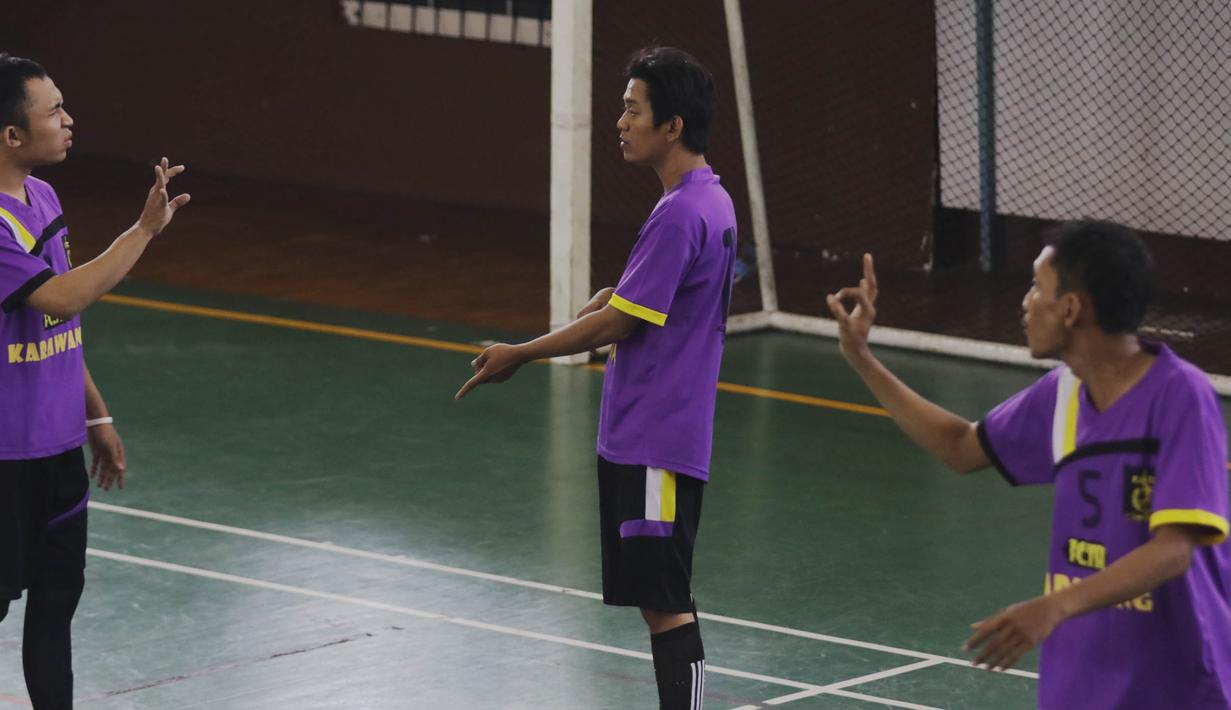 Pesepak bola menggunakan bahasa isyarat saat berkomunikasi di lapangan ketika mengikuti Kejuaraan Futsal Tuna Rungu di GOR Ciracas, Jakarta, Sabtu (7/11/2015). (Bola.com/Vitalis Yogi Trisna)