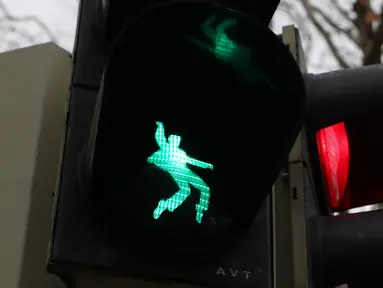 Sebuah lampu lalu lintas bergambar siluet Elvis Presley tengah berdansa di Friedberg, Jerman pada 7 Desember 2018. Para pengendara atau pun pejalan kaki akan melihat Elvis seolah sedang bergoyang dan bernyanyi. (Yann Schreiber / AFP)