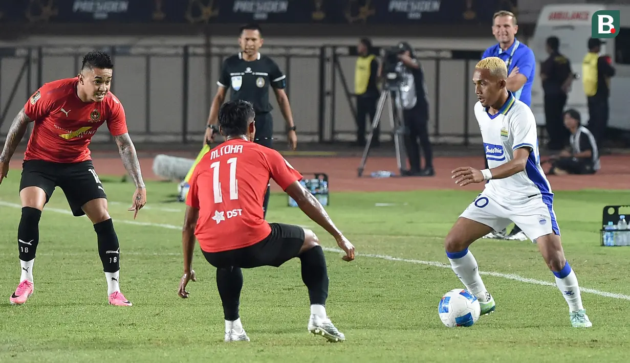 Bek kiri muda Persib Bandung, Ikhwan Tanamal (kanan), berusaha melewati hadangan pemain DPMM FC Brunei Darussalam, Muhammad Toha (tengah), pada laga kedua Grup A Piala Presiden 2026 di Stadion Si Jalak Harupat, Soreang, Kabupaten Bandung, Selasa (28/7/2026). Ikhwan tampil percaya diri saat mendapat kesempatan bermain dan ikut membantu Persib meraih kemenangan 1-0 yang memastikan langkah Maung Bandung ke babak semifinal. (Bola.com/Erwin Snaz)