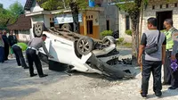 Kondisi mobil Xenia terbalik dan anggota Satlantas Polres Tuban ketika olah tempat kejadian perkara. (Adirin/Liputan6.com)