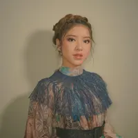Tiara Andini juga cocok dengan mengenakan dress bergaya Victorian. Dress bermotif ini dilengkapi dengan lace berwarna biru dan belt berwarna hitam. Rambut yang ditata bergaya up do dengan sentuhan akhir kepang.