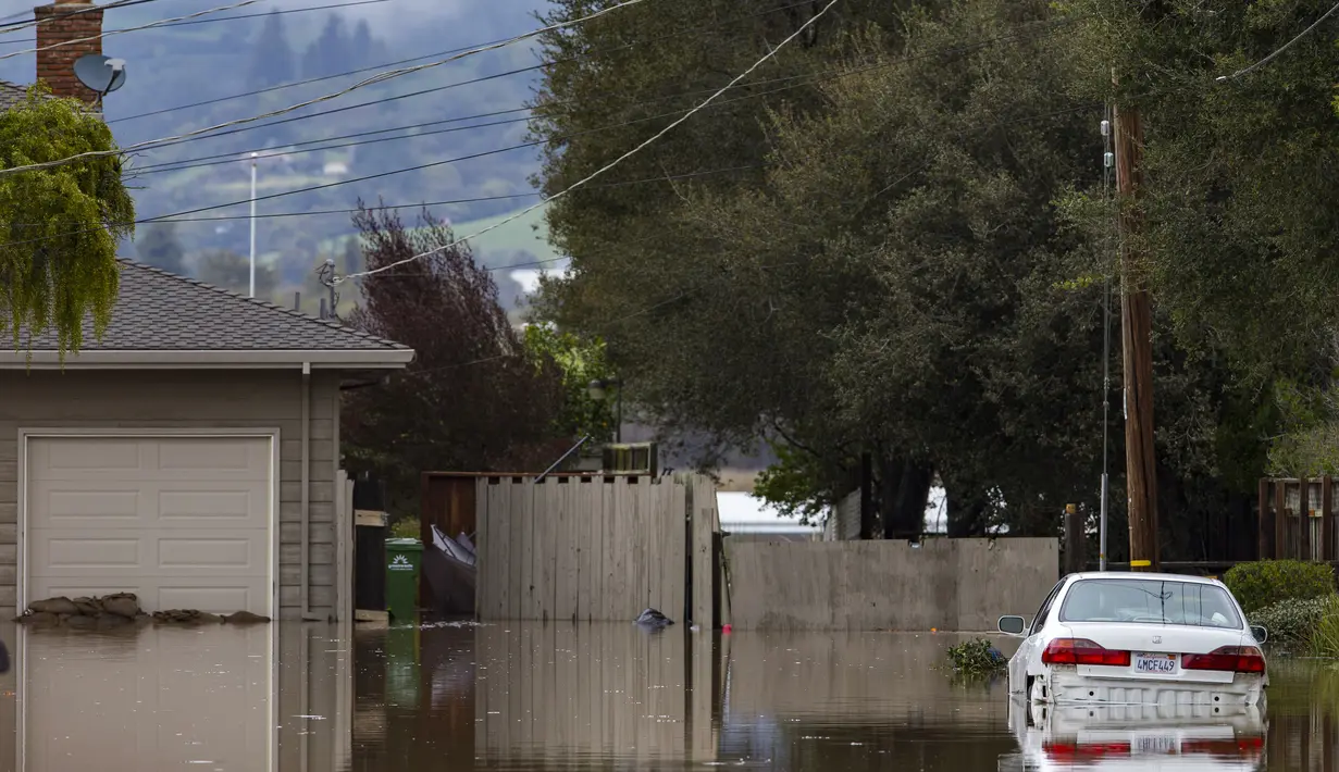 Sebuah mobil terendam banjir di Watsonville, California, Jumat, 10 Maret 2023. Lebih dari 9.000 penduduk California berada di bawah perintah evakuasi pada hari Jumat karena sungai atmosfer baru membawa hujan lebat, badai petir, dan angin kencang, meluapnya sungai dan anak sungai serta membanjiri beberapa jalan raya utama selama perjalanan pagi. (AP Photo/Nic Coury)le, California, Jumat, 10 Maret 2023.