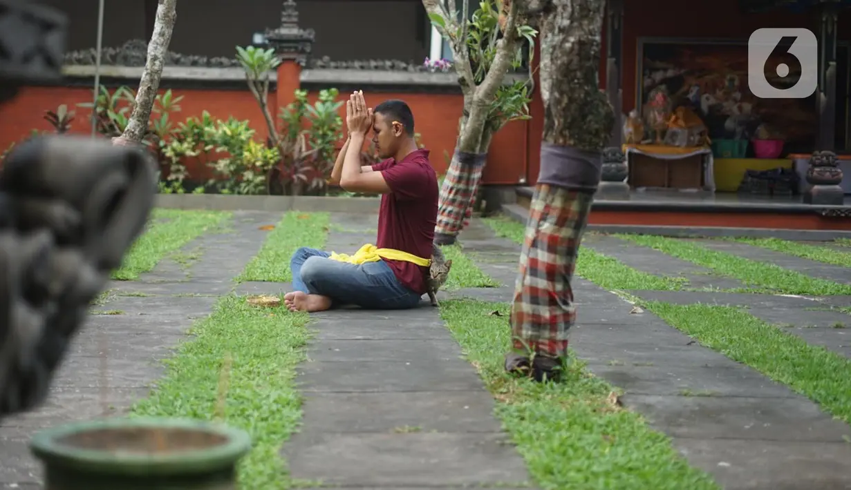 Umat Hindu berdoa di Pura Widya Dharma yang sepi di kawasan Cibubur, Jakarta Timur, Selasa (24/3/2020). Pembatasan aktivitas menjelang Hari Raya Nyepi tahun baru Saka 1942 dilakukan sesuai dengan imbauan pemerintah untuk antisipasi penyebaran virus corona Covid-19. (Liputan6.com/Immanuel Antonius)