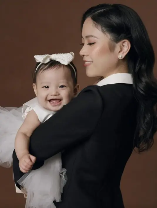 Jessica juga membagikan potretnya saat menggendong baby Julia Eden yang kenakan dress tutu bernuansa putih.  [Foto: Instagram/ Jessica/ Valencia Tanoe]