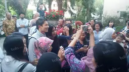 Pebalap Manor Racing asal Indonesia, Rio Haryanto, diajak berfoto bersama warga Indonesia saat hadir dalam acara meet and greet di Kantor KBRI Wina, Austria, Selasa (28/6/2016). (Bola.com/Reza Khomaini)