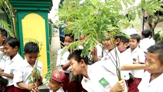 Siswa SD di lereng Gunung Slamet menanam pohon sebagai tabungan pendidikan dengan bimbingan guru. (Liputan6.com/Muhamad Ridlo)