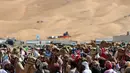 Para pemilik mempersiapkan unta mereka untuk mengikuti lomba balap Liwa 2018 Moreeb Dune Festival di gurun Liwa, Abu Dhabi (26/12). (AFP Photo/Karim Sahib)