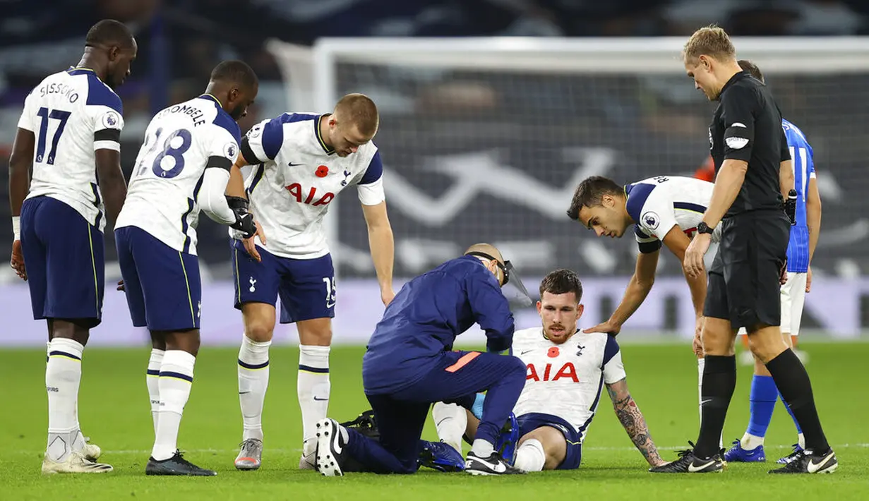 Pemain Tottenham Hotspur Pierre-Emile Hojbjerg menerima perawatan saat menghadapi Brighton and Hove Albion pada pertandingan Liga Premier Inggris di Tottenham Hotspur Stadium, London, Minggu (1/11/2020). (Julian Finney/Pool via AP)