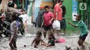 Anak anak bermain air di sebagian Jalan Bungur Besar Raya yang tergenang, Jakarta, Selasa (18/1/2022). Genangan air di sebagian Jalan Bungur Besar Raya dimanfaatkan anak-anak untuk bermain meski berbahaya. (Liputan6.com/Helmi Fithriansyah)