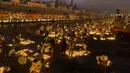 Orang-orang menyalakan lampu di tepi sungai Saryu di Ayodhya, India, Rabu (3/11/2021). Lebih dari 900.000 lampu minyak dinyalakan dan terus menyala selama 45 menit saat kota Ayodhya mempertahankan Rekor Dunia Guinness sebagai bagian dari perayaan festival Diwali. (AP Photo/Rajesh Kumar Singh)