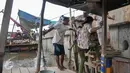 Warga menaiki tangga saat turun dari perahu eretan di wilayah Kampung Pulo, Jakarta Timur, Rabu (28/12). Meski penumpang tak seramai dulu, perahu eretan tetap bertahan diantara tembok beton normalisasi kali Ciliwung. (Liputan6.com/Yoppy Renato)