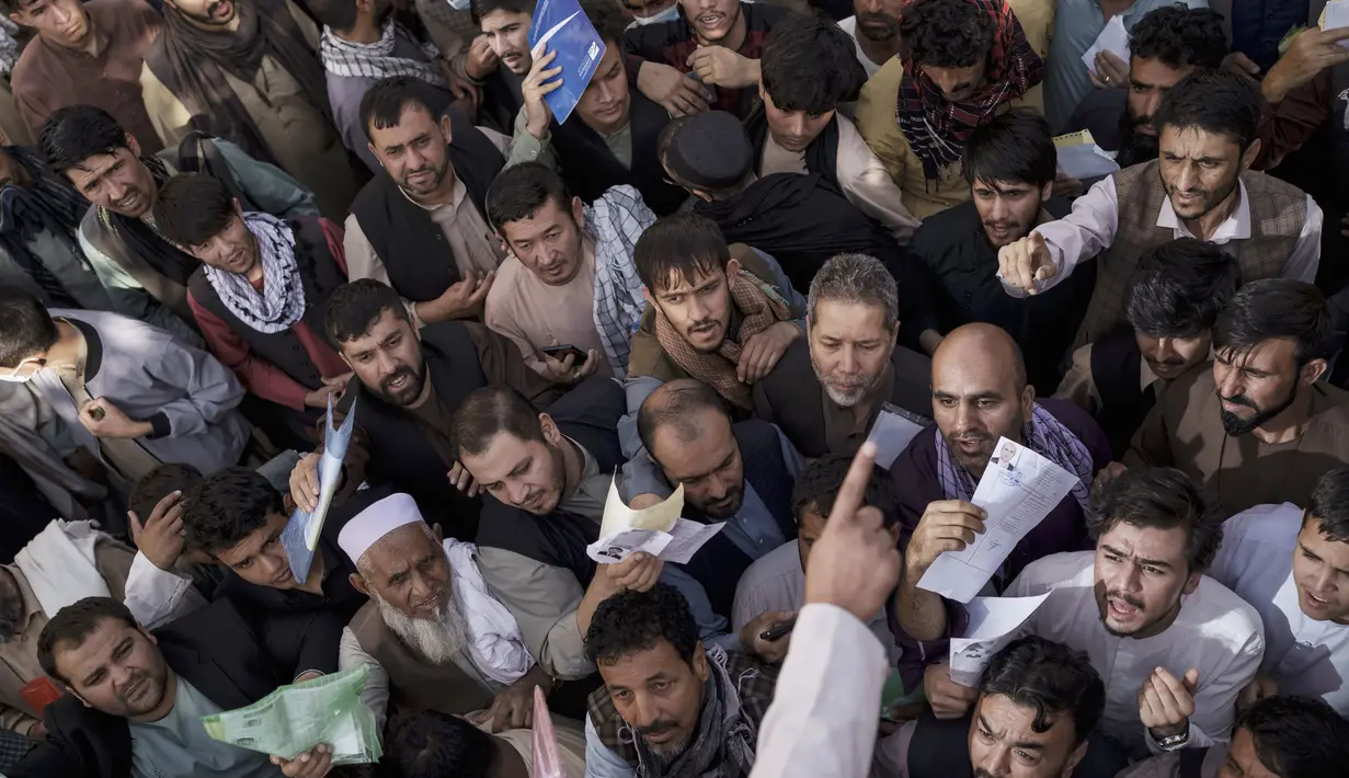 Warga berkerumun di depan kantor keimigrasian yang baru-baru ini dibuka kembali di Kabul, Afghanistan, Rabu (6/10/2021). Mereka mengantre setelah Taliban mengumumkan akan mengeluarkan paspor yang disetujui oleh pemerintahan sebelumnya. (AP Photo/Felipe Dana)