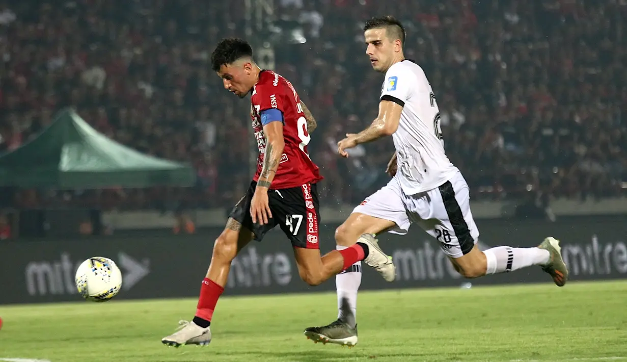 Gelandang Bali United, Stefano Lilipaly, beradu cepat dengan bek Madura United, Ante Bakmaz, pada laga Liga 1 2019 di Stadion Kapten I Wayan Dipta, Bali, Minggu (22/12). Bali kalah 0-2 dari Madura. (Bola.com/Aditya Wany)