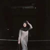 Awkarin mengunggah beberapa potret dirinya yang akhirnya pergi menjalankan ibadah Umroh bersama keluarga dan sahabat. Di sini, Awkarin tampil manis mengenakan gamis abu-abu dan hijab hitam serba polos. [Foto: Instagram/narinkovilda]