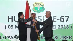 Ketua Harian PBSI, Alex Tirta (kanan) menyerahkan bendera Merah Putih kepada CdM tim Thomas dan Uber Indonesia, Achmad Budiharto saat upacara pelepasan di Jakarta, Selasa (8/5). (Liputan6.com/Helmi Fithriansyah)