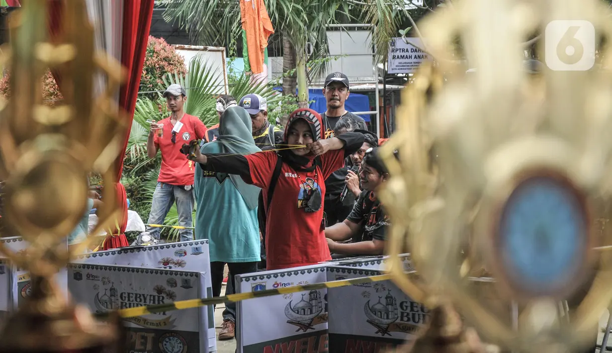 Selain pria, kaum perempuan juga turut meramaikan lomba katapel  saat Gebyar Budaya Nganten Temat II di RPTRA Dahlia, Kramat Jati, Jakarta Timur, Minggu (26/6/2022). Lomba katapel tersebut digelar oleh Komunitas Ketapel Condet (Kecot) bersama Wali Kota Jakarta Timur. (merdeka.com/Iqbal S Nugroho)