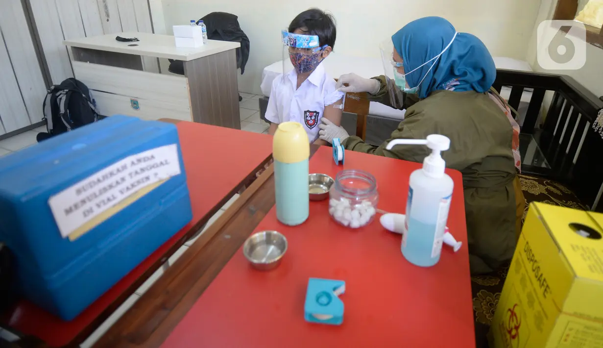Petugas Puskesmas melakukan imunisasi campak kepada siswa kelas I saat pelaksanaan Bulan Imunisasi Anak Sekolah (BIAS) di SDN Serua 3, Ciputat, Tangsel, Selasa (1/9/2020). Kegiatan itu untuk memberikan kekebalan terhadap siswa dari penyakit campak, difteri dan tetanus. (merdeka.com/Dwi Narwoko)