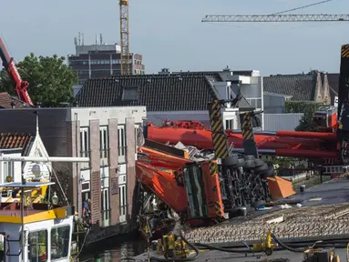 Dua mesin derek jatuh ke rumah warga di Alphen aan den Rijn, Belanda, Senin (3/8/2015) waktu setempat. Dua mesin derek yang sedang memperbaiki jembatan ambruk ke rumah yang ada di dekatnya dan melukai 20 orang. (AFP PHOTO/ANP/LEX VAN LIESHOUT)