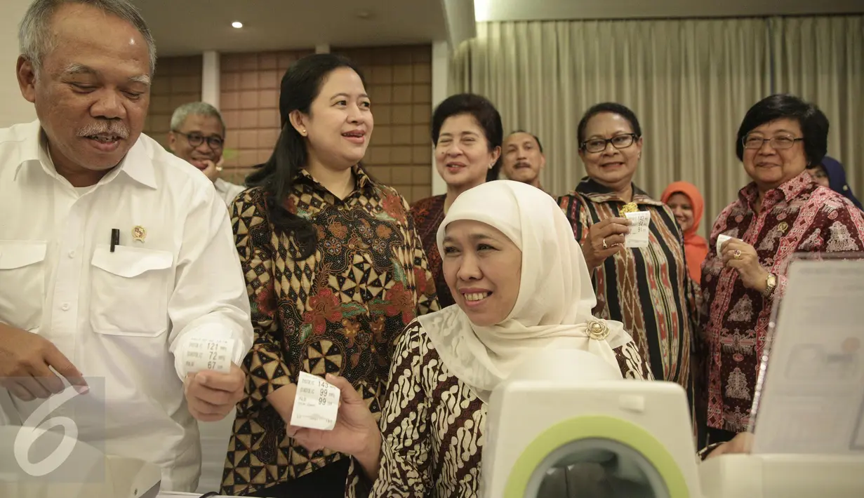 Menteri Sosial Khofifah Indar Parawansa dan Menteri Pekerjaan Umum dan Perumahan Rakyat Basuki Hadimuljono menunjukan hasil periksa tekanan darah di kantor Kemenko PMK Jakarta, Rabu (22/2). (Liputan6.com/Faizal Fanani)