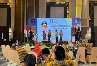 Menteri Hukum Supratman Andi Agtas saat menyerahkan penghargaan kepada Gubernur DIY Sri Sultan Hamengku Buwono X saat peresmian 438 Posbakum di kelurahan/desa se-DIY. (Liputan6.com/Kukuh Setyono)