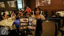 Aktivis Greenpeace Indonesia memperlihatkan menu makanan dan replika hiu saat menggelar kampanye di salah satu rumah makan , Jakarta, Minggu (12/7/2015). Aksi tersebut sebagai upaya menyelamatkan hiu dari kepunahan. (Liputan6.com/Faizal Fanani)