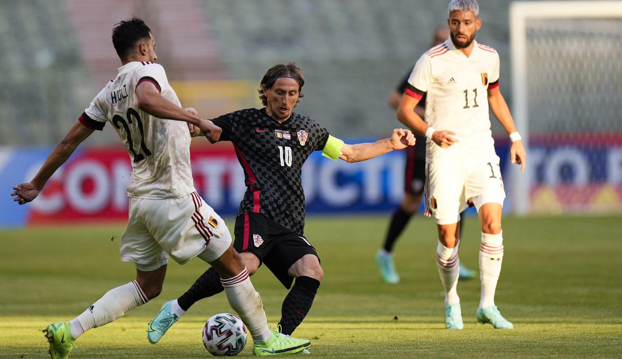 Gelandang Kroasia, Luka Modric (tengah) berebut bola dengan gelandang Belgia, Nacer Chadli dalam laga uji coba menjelang berlangsungnya Euro 2020 di King Baudouin Stadium, Brussels, Minggu (6/6/2021). Kroasia kalah 0-1 dari Belgia. (AP/Francisco Seco)