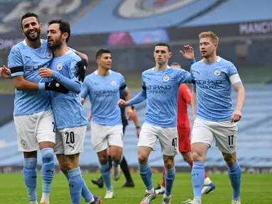 Gelandang Manchester City, Bernardo Silva (kedua dari kiri) melakukan selebrasi usai mencetak gol pertama timnya ke gawang Birmingham City dalam laga babak ke-3 Piala FA 2020/21 di Etihad Stadium, Minggu (10/1/2021). Manchester City menang 3-0 atas Birmingham City. (AFP/Oli Scarff/Pool)