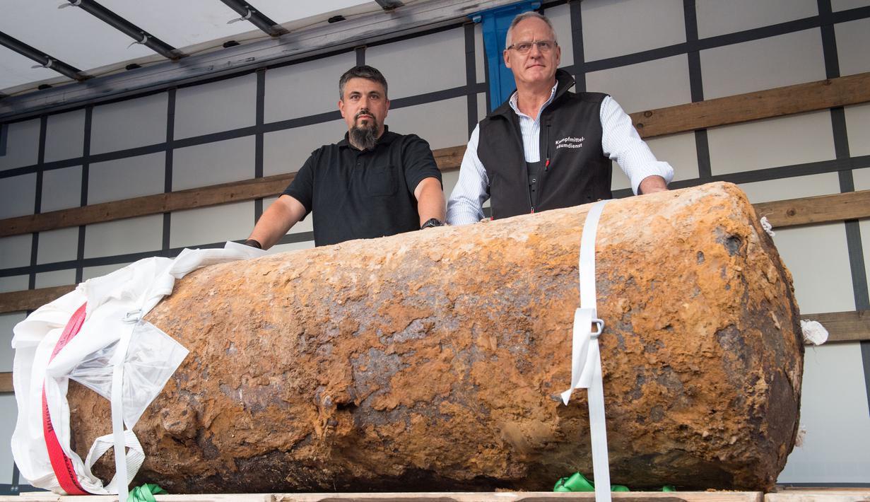 Pakar bom Rene Bennert dan Dieter Schweizler berpose di dekat bom Perang Dunia II di Frankfurt, Jerman, (3/9). Lebih dari 60.000 orang dievakuasi setelah sebuah bom 1.400 ton Perang Dunia II (tambang udara HC 4000) ditemukan. (AFP Photo/Thomas Lohnes)