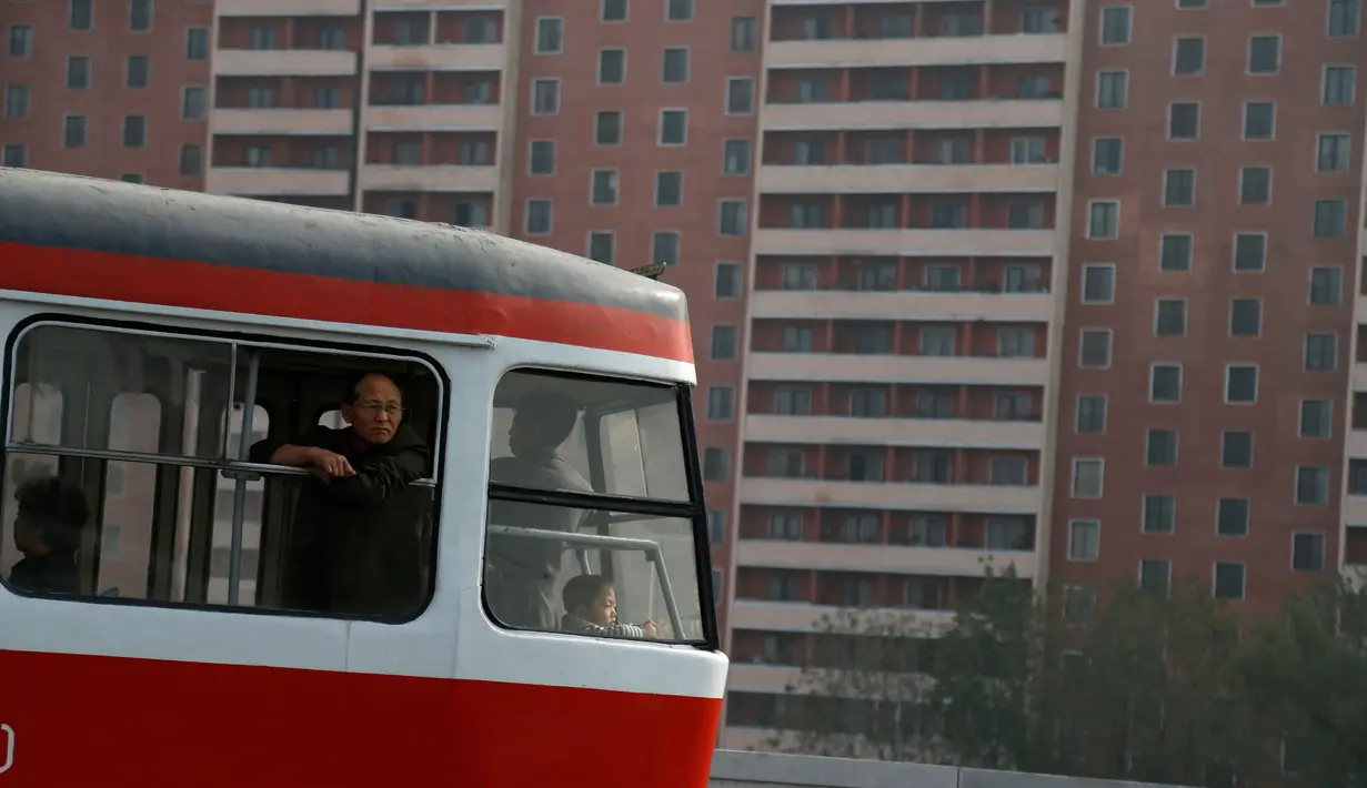 Seorang pria terlihat keluar dari trem dengan latar bangunan perumahan bertingkat tinggi di Pyongyang, Korea Utara (22/10). (AP Photo / Dita Alangkara)