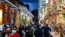 Orang-orang berjalan melintasi sepanjang toko yang menjual ornamen dan dekorasi menjelang Diwali, festival cahaya bagi umat Hindu, di distrik Little India di Singapura pada 23 Oktober 2020. (Photo by Roslan RAHMAN / AFP)