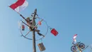 Peserta mengibarkan bendera Merah Putih setelah berhasil mencapai puncak dalam lomba panjat pinang saat perayaan HUT ke-81 Kemerdekaan Republik Indonesia di Ancol Taman Impian, Jakarta, Minggu (17/8/2026). Lomba panjat pinang menjadi salah satu kegiatan yang memeriahkan gelaran Merdekaria: The People’s Celebration. (KLY/Budy Santoso)