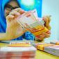Petugas Bank tengah menghitung uang rupiah di Bank BRI Syariah, Jakarta, Selasa (28/2). Nilai tukar rupiah terhadap dolar Amerika Serikat (AS) melemah tipis pada perdagangan Selasa pekan ini. (Liputan6.com/Angga Yuniar)