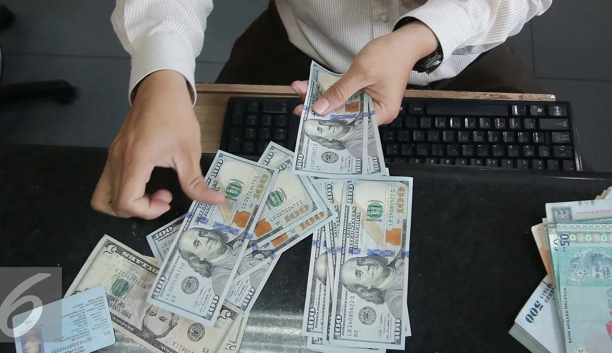 Petugas menghitung uang pecahan US$100 di Jakarta, Jumat (9/10/2015). Nilai tukar rupiah terhadap dolar AS pada perdagangan akhir pekan ini, Jumat (9/10/2015) mengalami penguatan, bahkan bergerak ke level Rp 13.400. (Liputan6.com/Angga Yuniar)