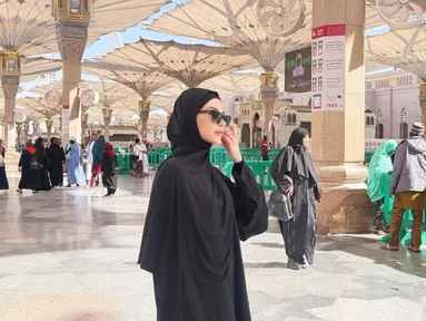 Selama umrah, gaya hijab Alyssa Daguise menjadi sorotan karena sederhana namun tetap elegan. Di Masjid Nabawi, ia terlihat mengenakan abaya hitam dengan hijab serasi, lengkap dengan kacamata hitam yang membuat tampilannya terlihat modern. Ekspresi khusyuk dan ketenangan yang terpancar dari dirinya mencerminkan kedamaian spiritual yang ia rasakan. (Liputan6.com/IG/@alyssadaguise)