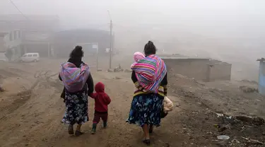 Warga berjalan melalui kabut dingin dan tebal pada hari resmi pertama musim dingin, di lingkungan Ticlio Chico di pinggiran Lima, Peru, Selasa (21/6/2022). Suhu di ibu kota adalah yang terendah dalam 25 tahun, menurut National Layanan Meteorologi dan Hidrologi Peru. (AP Photo/Martin Mejia)