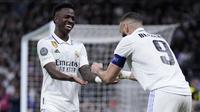 Striker Real Madrid, Karim Benzema (kanan), merayakan gol yang dicetaknya ke gawang Liverpool bersama Vinicius Junior yang memberinya assist dalam pertandingan leg kedua 16 besar Liga Champions, Kamis (16/3/2023) dini hari WIB. Real Madrid menang 1-0 dan lolos ke perempat final Liga Champions dengan agregat 6-2. (AP Photo/Bernat Armangue)