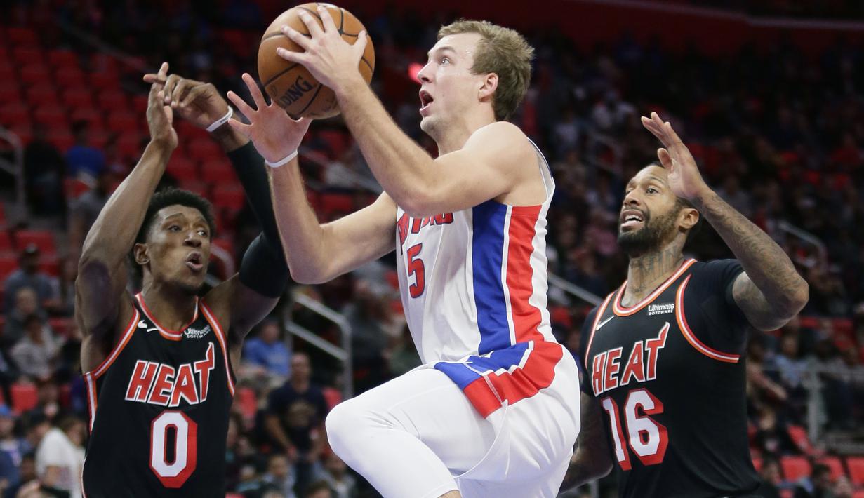 Pemain Detroit Pistons, Luke Kennard (5) melakukan lay up melewati dua pemain Miami Heat pada laga NBA basketball game di Little Caesars Arena, Detroit, (12/11/2017). Detroit Pistons menang 112-103. (AP/Duane Burleson)
