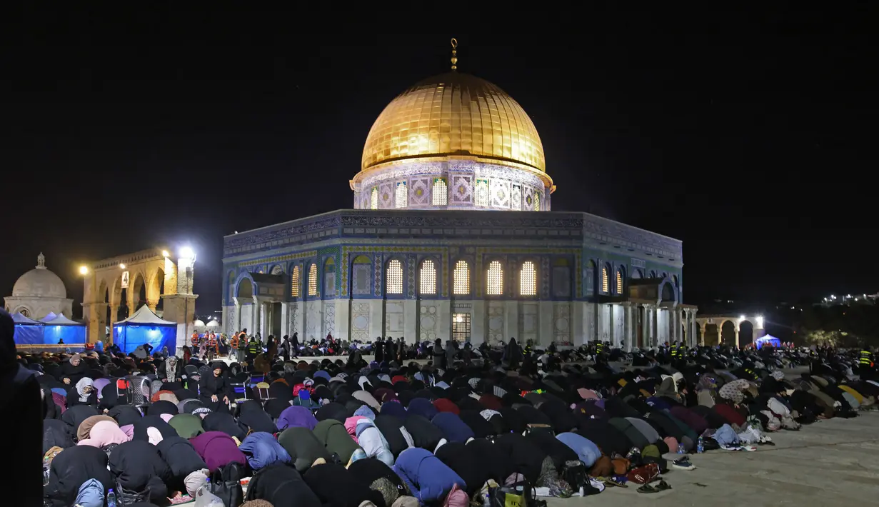 Muslim Palestina menjalani ibadah salat saat memburu malam Lailatul Qadar di luar Kubah Batu (Dome of the Rock) di kompleks Masjid Al-Aqsa di Yerusalem (8/5/2021). (AFP/Ahmad Gharabli)