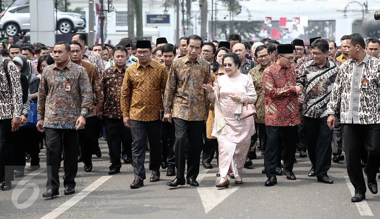 Presiden Jokowi dan Megawati Soekarnoputri berjalan kaki menuju situs penjara Banceuy usai puncak perayaan peringatan Hari Pancasila di Gedung Merdeka, Bandung, Rabu (1/6). Penjara itu pernah jadi tempat penahanan Bung Karno. (Liputan6.com/Faizal Fanani)