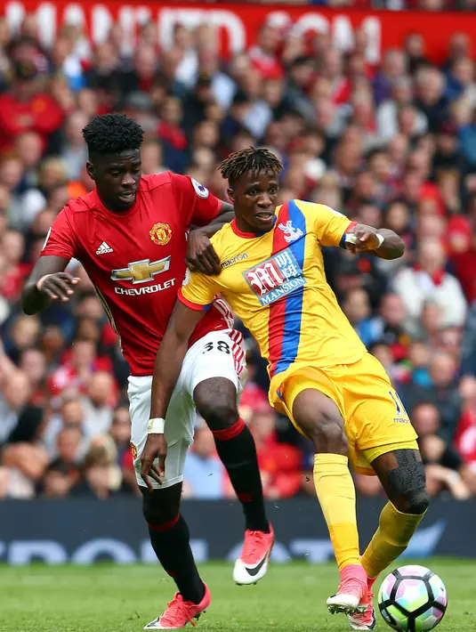 Gelandang Manchester United, Alex Tuanzebe, berebut bola dengan striker Crystal Palace, Wilfried Zaha, pada laga Premier League di Stadion Old Trafford, Inggris, Minggu (21/5/2017). MU menang 2-0 atas Palace. (EPA/Tim Keeton)